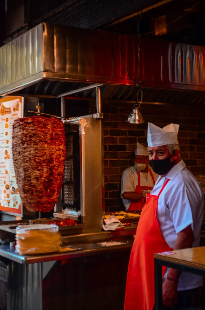 Cocineros preparando tacos en una taquería