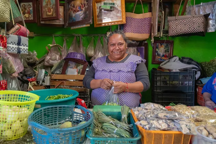 Vendedora sonriendo en su puesto del mercado